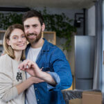 A young couple with keys moving into a new home