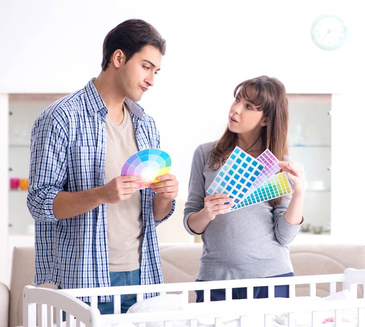 Young parents considering color options for the nursery they are painting.